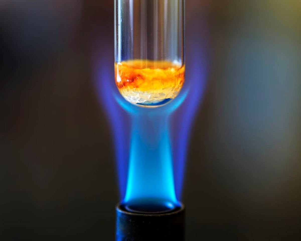 Heating a testtube containing sample using bunsen burner in a chemistry lab