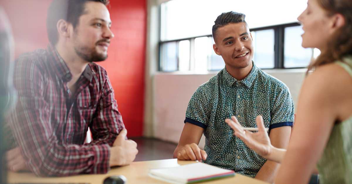 In this picture, the faces of two men can be seen who are discussing with another person.
